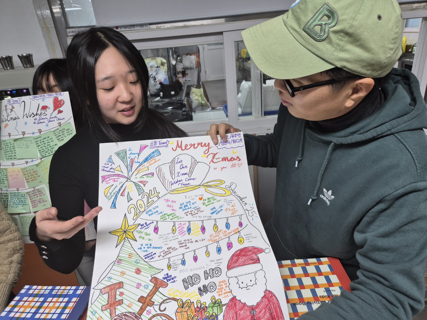 Young woman presenting a hand-drawn Christmas Wishes poster from scholarship students at a community gathering